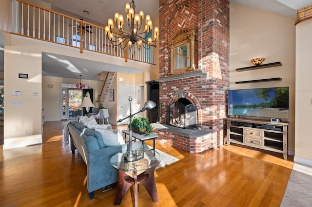 living room with a fireplace, wood-type flooring, and a towering ceiling