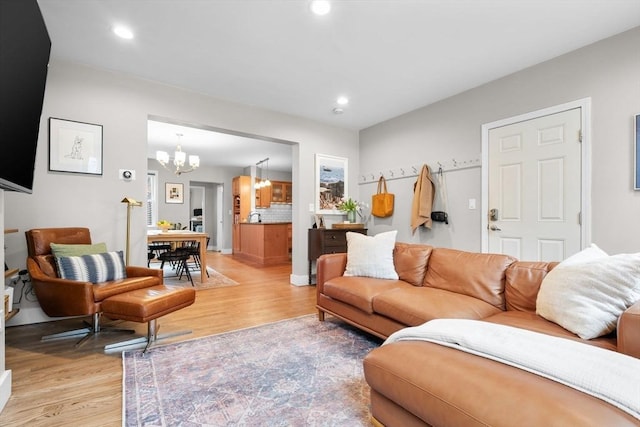 living room featuring recessed lighting, an inviting chandelier, and light wood-style floors