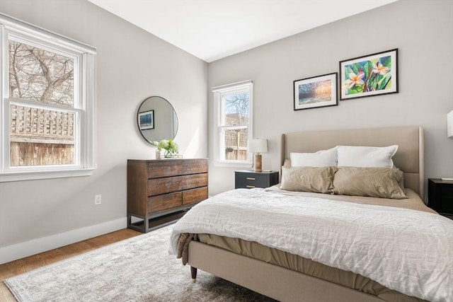 bedroom with baseboards and wood finished floors