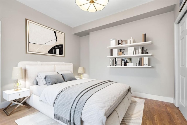 bedroom featuring baseboards and wood finished floors