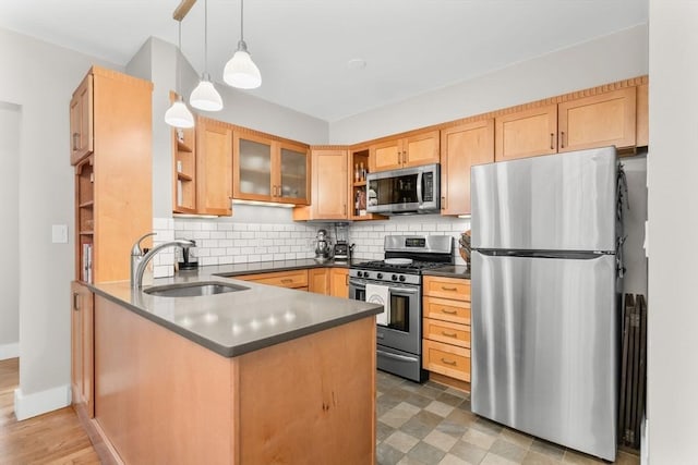 kitchen featuring a sink, appliances with stainless steel finishes, open shelves, and dark countertops
