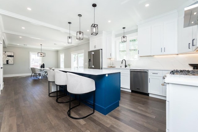 kitchen with dark wood-style flooring, appliances with stainless steel finishes, a center island, light countertops, and white cabinetry