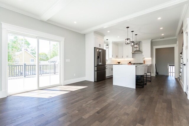 kitchen with wall chimney range hood, recessed lighting, high quality fridge, and dark wood finished floors