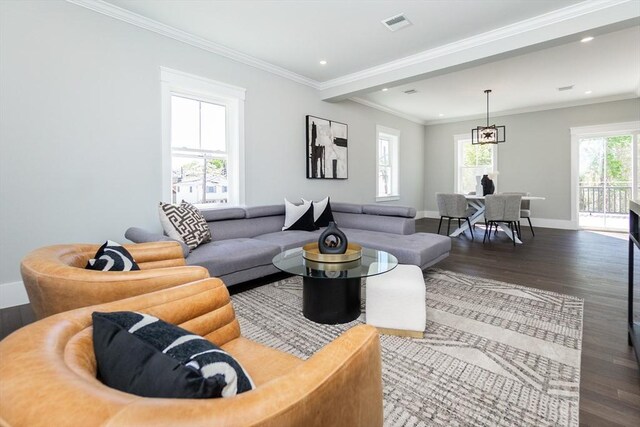 living area with crown molding, baseboards, wood finished floors, and visible vents
