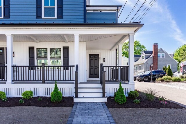 entrance to property featuring board and batten siding and covered porch
