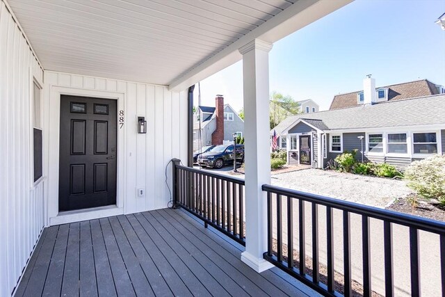 wooden terrace with a residential view and covered porch