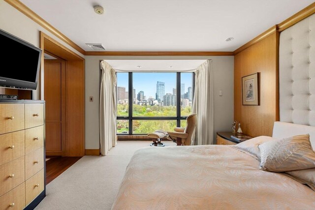 2 Commonwealth Ave Unit 14B, Boston, MA 02116 - bedroom with crown molding, light colored carpet, a view of city, baseboards, and visible vents
