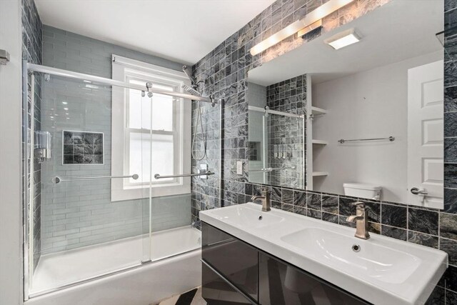 117 Sycamore St Unit 1, Boston, MA 02131 - full bathroom featuring tile walls, enclosed tub / shower combo, double vanity, toilet, and backsplash
