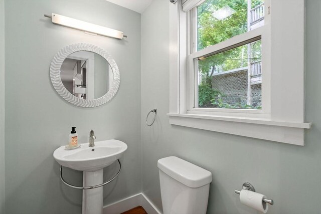 117 Sycamore St Unit 1, Boston, MA 02131 - half bathroom featuring toilet and baseboards