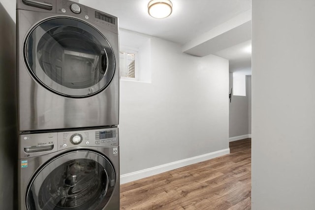 117 Sycamore St Unit 1, Boston, MA 02131 - laundry room with stacked washing machine and dryer, wood finished floors, and baseboards