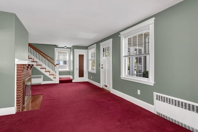 24 Neponset Rd, Quincy, MA 02169 - carpeted entryway with radiator, a brick fireplace, baseboards, and stairway