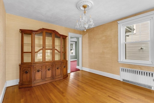 24 Neponset Rd, Quincy, MA 02169 - spare room featuring radiator, baseboards, a chandelier, and wood-type flooring