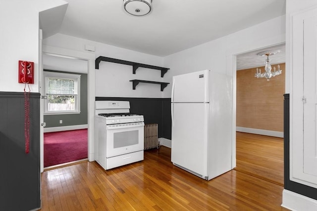24 Neponset Rd, Quincy, MA 02169 - kitchen with white appliances, radiator heating unit, a chandelier, hardwood / wood-style flooring, and baseboards