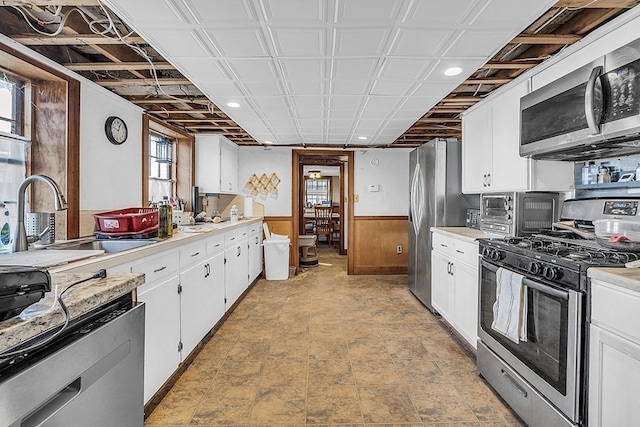 kitchen featuring appliances with stainless steel finishes, white cabinetry, and a wealth of natural light