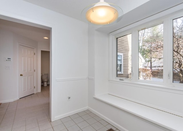 hall featuring light tile patterned floors and plenty of natural light