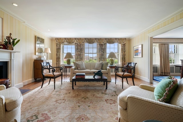 living room featuring light hardwood / wood-style flooring, a healthy amount of sunlight, and crown molding