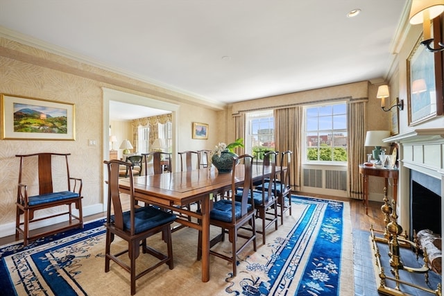 dining area featuring wood-type flooring and crown molding