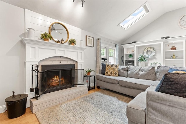 25 12th Ave, Halifax, MA 02338 - living area featuring wood finished floors, vaulted ceiling, a skylight, and a fireplace