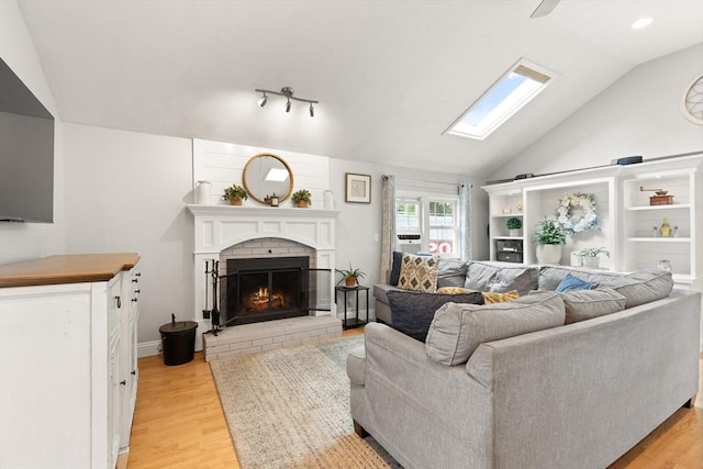 25 12th Ave, Halifax, MA 02338 - living room featuring vaulted ceiling, light wood-style floors, a fireplace, and a skylight