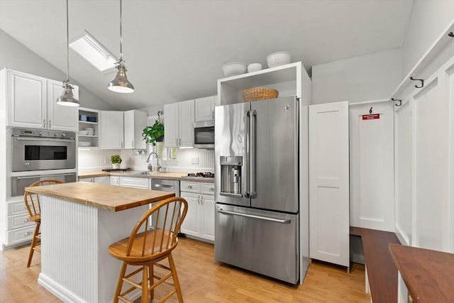 25 12th Ave, Halifax, MA 02338 - kitchen with appliances with stainless steel finishes, wood counters, open shelves, white cabinetry, and a kitchen breakfast bar