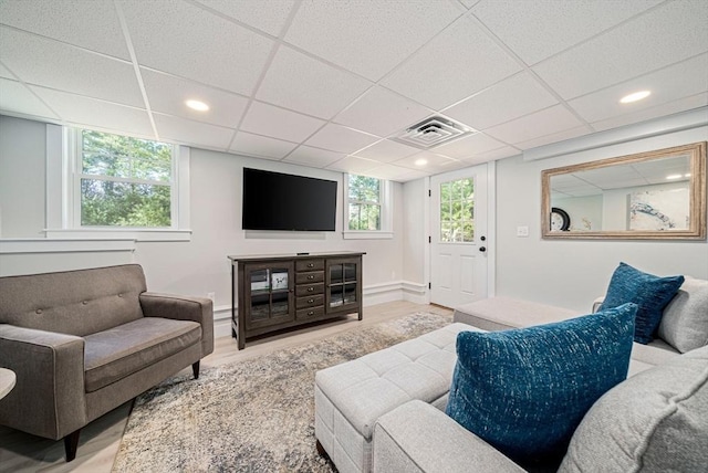 living room with a paneled ceiling, recessed lighting, wood finished floors, and visible vents