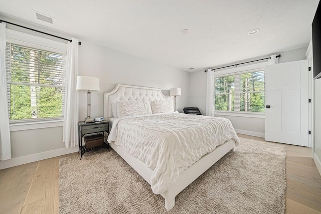 bedroom featuring baseboards, visible vents, and light wood-type flooring