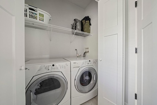 clothes washing area with independent washer and dryer and laundry area