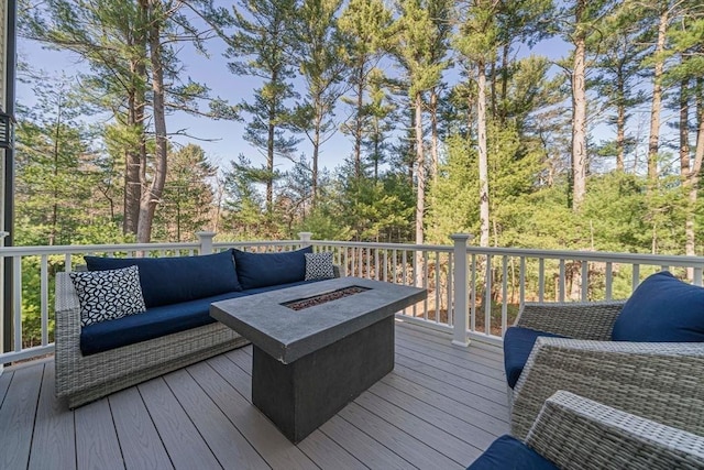 deck featuring an outdoor living space with a fire pit