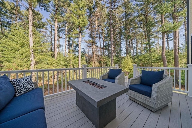 wooden deck featuring an outdoor living space with a fire pit