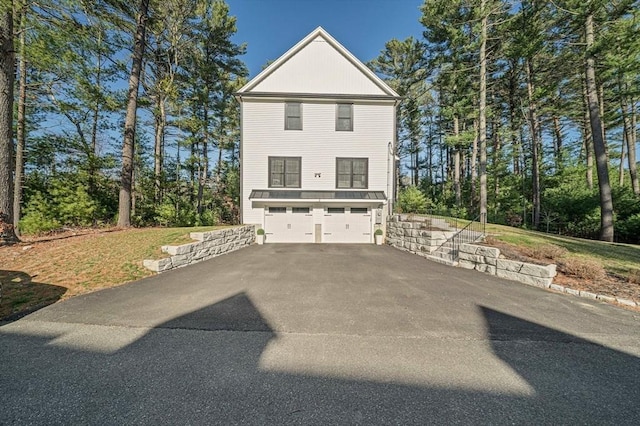 view of property exterior featuring a garage and aphalt driveway