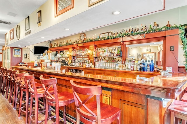 bar with light hardwood / wood-style flooring