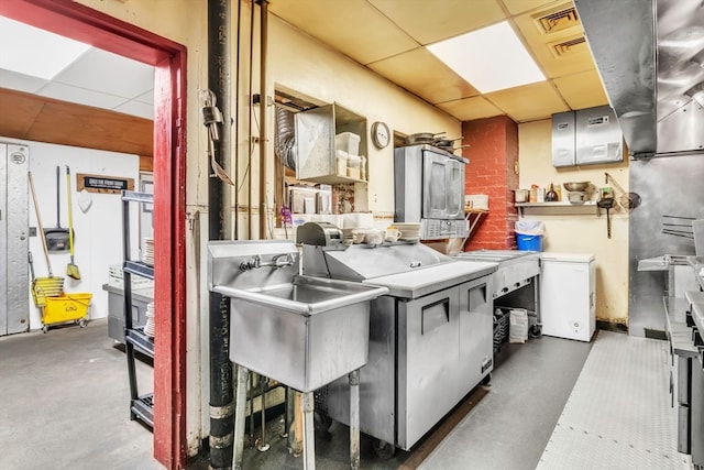 interior space with a drop ceiling, sink, and washer / dryer