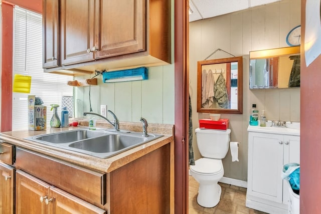 kitchen featuring wood walls and sink