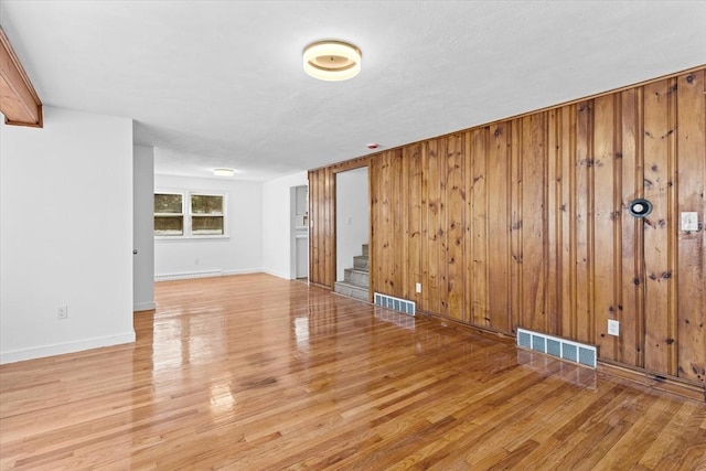 260 Great Rd, Stow, MA 01775 - unfurnished room featuring wood finished floors, wood walls, visible vents, and stairs