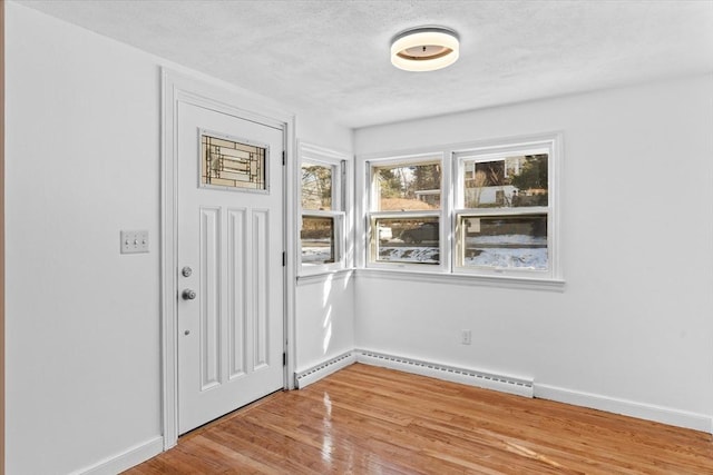 260 Great Rd, Stow, MA 01775 - foyer entrance with a baseboard heating unit, light wood-style floors, baseboards, and a textured ceiling