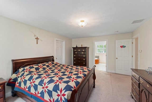 bedroom with light carpet, ensuite bathroom, and baseboards
