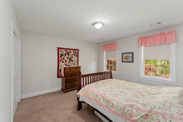 bedroom featuring light carpet, baseboards, and a closet
