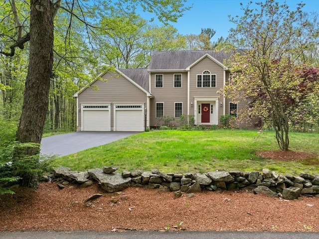 colonial inspired home featuring a garage, asphalt driveway, and a front yard