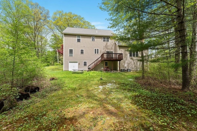 rear view of property featuring stairway, a deck, and a yard