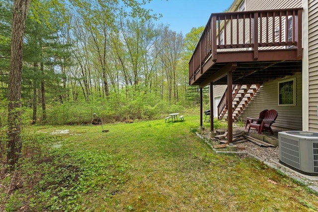 view of grassy yard featuring cooling unit, stairway, and a wooden deck