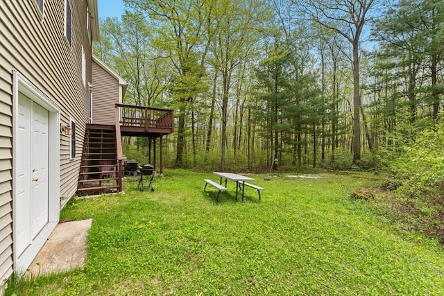 view of green lawn with stairway and a wooden deck