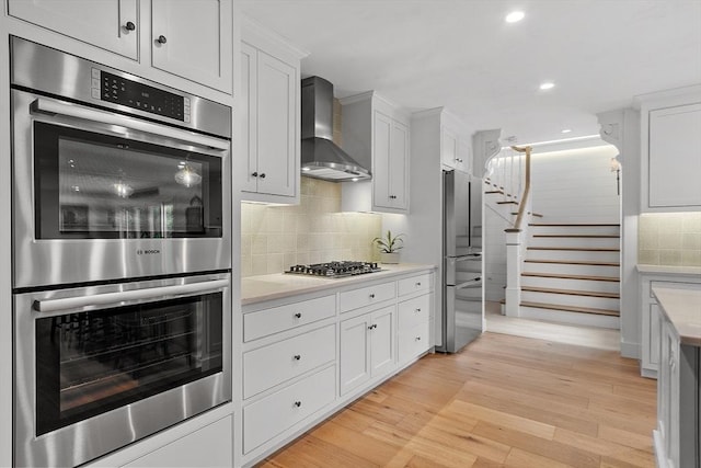124 Osgood Rd, Charlton, MA 01507 - kitchen with wall chimney range hood, appliances with stainless steel finishes, light countertops, tasteful backsplash, and recessed lighting