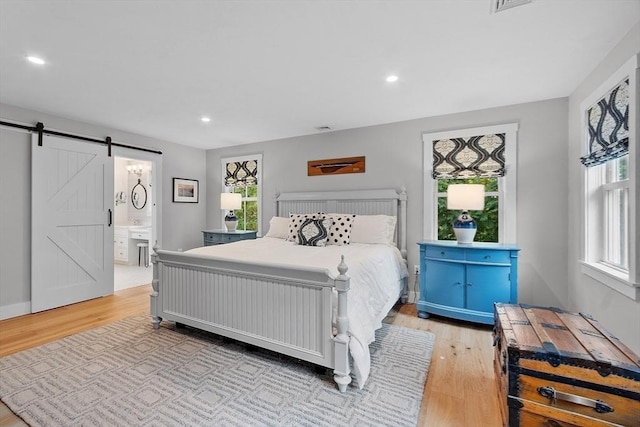 124 Osgood Rd, Charlton, MA 01507 - bedroom featuring a barn door, light wood-style flooring, recessed lighting, and ensuite bath