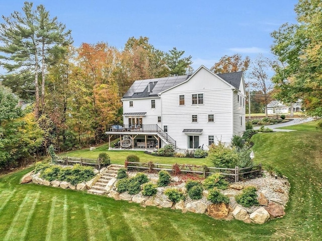 124 Osgood Rd, Charlton, MA 01507 - rear view of house with stairs, a wooden deck, a lawn, and solar panels