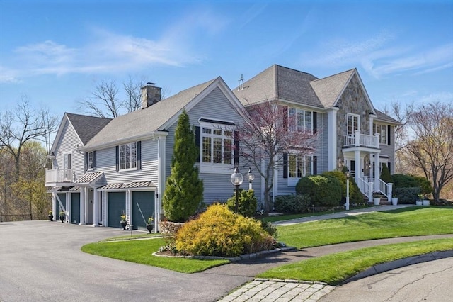 58 Bridle Path, Tewksbury, MA 01876 - exterior space with an attached garage, aphalt driveway, a front yard, a chimney, and a balcony