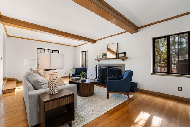 living room featuring crown molding, beam ceiling, and light wood-type flooring