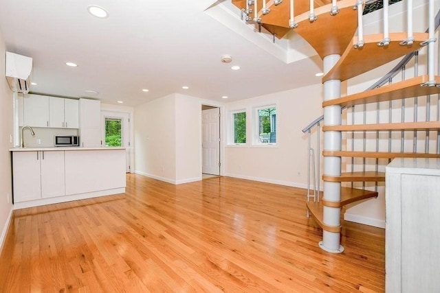670 Front St, Marion, MA 02738 - unfurnished living room featuring recessed lighting, light wood finished floors, plenty of natural light, and an AC wall unit