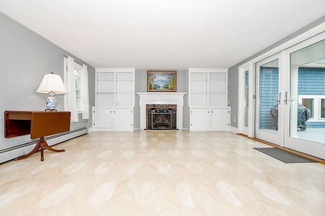 670 Front St, Marion, MA 02738 - unfurnished living room with a brick fireplace, baseboard heating, built in shelves, and french doors