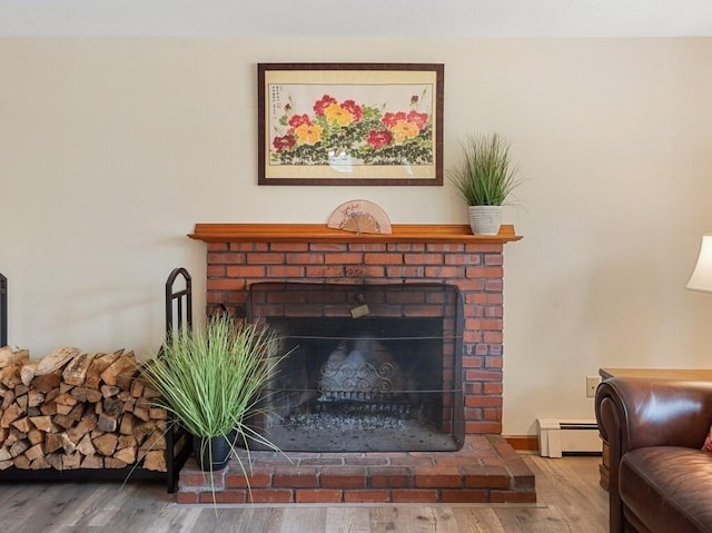 room details featuring a brick fireplace, wood finished floors, and a baseboard radiator