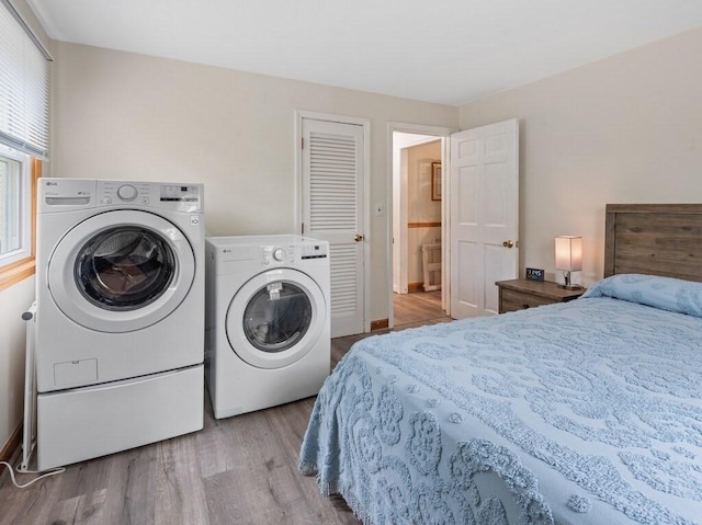 bedroom featuring independent washer and dryer and wood finished floors